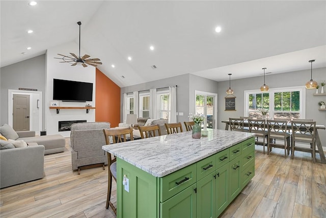 100 Grandview Dr, Anderson, SC 29625 - kitchen with green cabinetry, a kitchen bar, a kitchen island, light wood finished floors, and high vaulted ceiling