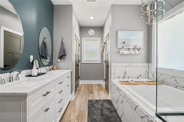 100 Grandview Dr, Anderson, SC 29625 - bathroom featuring a bath, double vanity, wood finished floors, baseboards, and a stall shower
