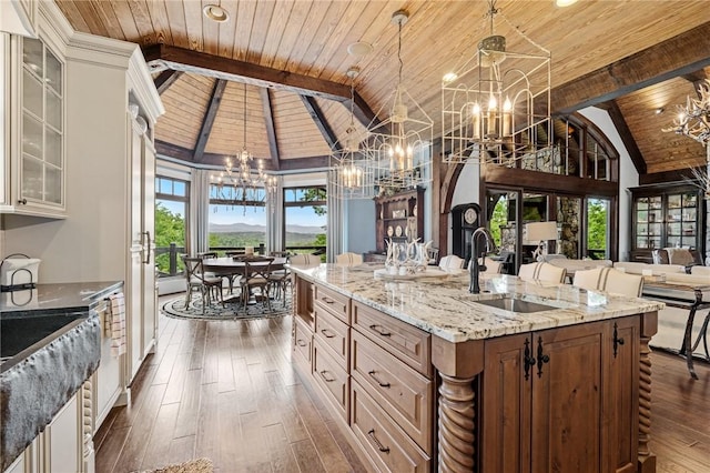 194 Cool Water Way, Sunset, SC 29685 - kitchen with a chandelier, wood ceiling with exposed beams, a sink, glass insert cabinets, and light stone countertops