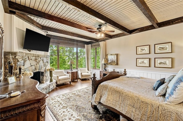 194 Cool Water Way, Sunset, SC 29685 - bedroom featuring wooden ceiling with exposed beams, wood finished floors, wainscoting, a fireplace, and a ceiling fan
