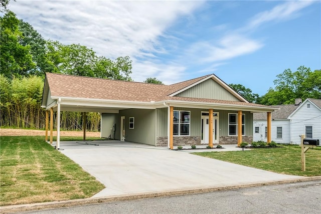 106 N St, Belton, SC 29627 - view of front facade featuring concrete driveway, a front lawn, an attached carport, stone siding, and a shingled roof