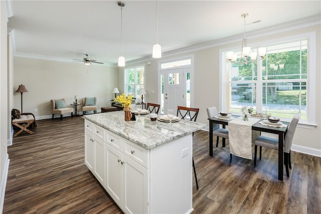 106 N St, Belton, SC 29627 - kitchen featuring a center island, dark wood-type flooring, ornamental molding, white cabinets, and hanging light fixtures