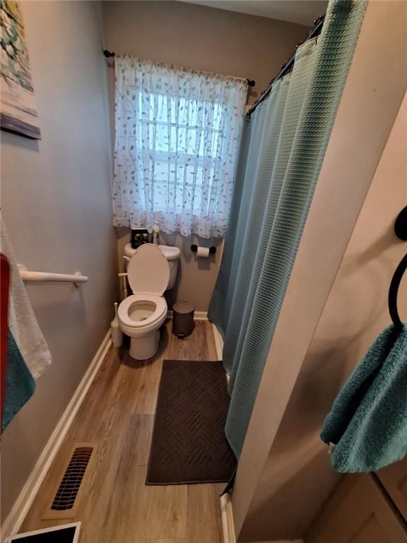 709 Ferry St, Anderson, SC 29626 - bathroom with toilet, wood finished floors, curtained shower, and baseboards