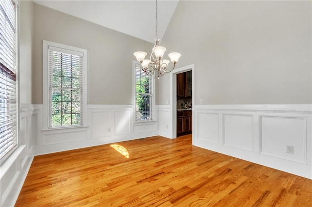 206 Waverly Hall Ln, Simpsonville, SC 29681 - unfurnished dining area with a chandelier, wainscoting, healthy amount of natural light, light wood-type flooring, and vaulted ceiling