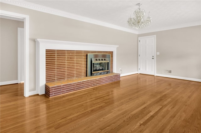 1142 Fox Squirrel Ridge Rd, Pickens, SC 29671 - unfurnished living room with a chandelier, baseboards, wood finished floors, ornamental molding, and a brick fireplace