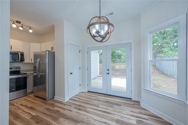 2413 Annandale Dr, Anderson, SC 29621 - kitchen featuring appliances with stainless steel finishes, a chandelier, crown molding, light wood-style flooring, and white cabinetry