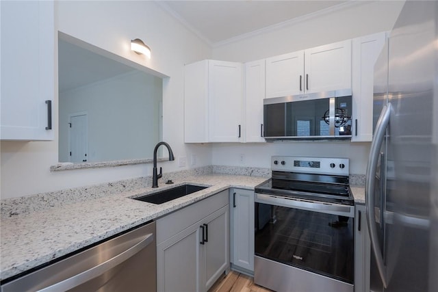 2413 Annandale Dr, Anderson, SC 29621 - kitchen featuring appliances with stainless steel finishes, a sink, ornamental molding, light stone counters, and white cabinetry