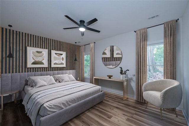 2413 Annandale Dr, Anderson, SC 29621 - bedroom with an accent wall, multiple windows, wallpapered walls, baseboards, and wood finished floors