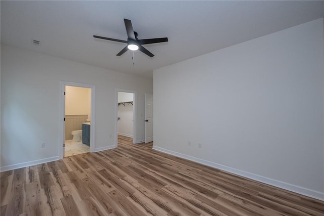 2413 Annandale Dr, Anderson, SC 29621 - unfurnished bedroom featuring wood finished floors, connected bathroom, a spacious closet, baseboards, and a ceiling fan