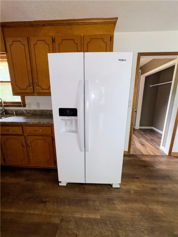 5265 Slater Rd, Anderson, SC 29621 - kitchen featuring white fridge with ice dispenser, brown cabinets, dark countertops, and a sink