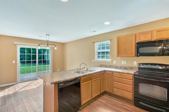 123 Stevens Ct, Williamston, SC 29697 - kitchen with black appliances, a sink, light wood-style flooring, a peninsula, and hanging light fixtures