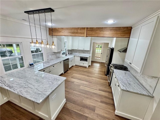 800 Holiday Dam Rd, Honea Path, SC 29654 - kitchen with appliances with stainless steel finishes, a peninsula, light stone counters, backsplash, and white cabinetry