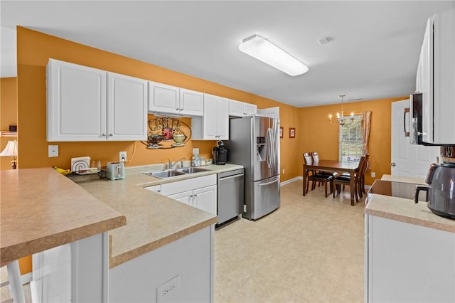 1014 Stoneham Cir, Anderson, SC 29626 - kitchen with stainless steel appliances, a sink, a peninsula, a chandelier, and white cabinets