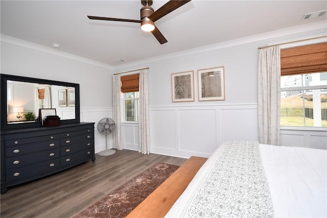 317 Encampment Blvd, Simpsonville, SC 29681 - bedroom featuring multiple windows, dark wood-style flooring, ornamental molding, a wainscoted wall, and a decorative wall