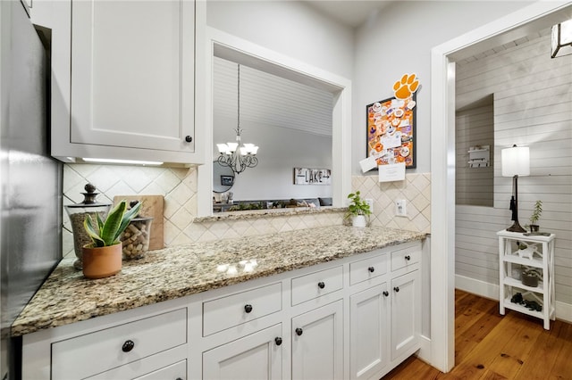 112 Orchard Cottage Way, Sunset, SC 29685 - kitchen with backsplash, white cabinetry, light wood-style floors, light stone countertops, and a chandelier