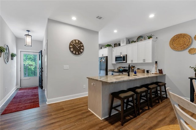 324 Sweetbriar Trl, Westminster, SC 29693 - kitchen with stainless steel appliances, a peninsula, white cabinets, a breakfast bar area, and dark wood-type flooring