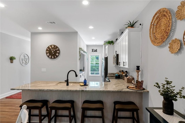 324 Sweetbriar Trl, Westminster, SC 29693 - kitchen featuring appliances with stainless steel finishes, light stone countertops, a peninsula, white cabinets, and a kitchen bar