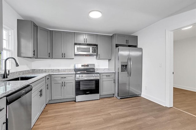 320 Fowler Rd, West Union, SC 29696 - kitchen featuring appliances with stainless steel finishes, a sink, gray cabinetry, light stone countertops, and light wood-style flooring