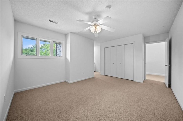 704 Loran Pointe Cir, Seneca, SC 29672 - unfurnished bedroom featuring light carpet, a closet, baseboards, a ceiling fan, and a textured ceiling