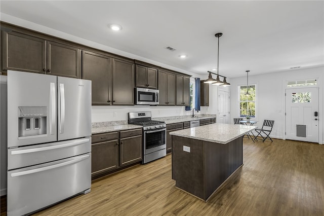 3401 Old Buncombe Rd, Greenville, SC 29617 - kitchen featuring appliances with stainless steel finishes, dark brown cabinetry, wood finished floors, light stone countertops, and recessed lighting
