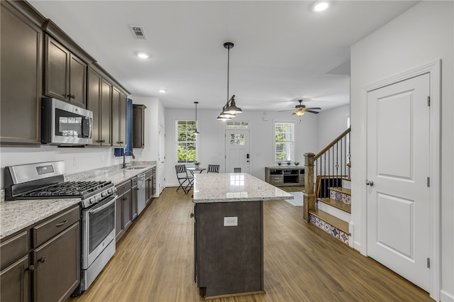 3401 Old Buncombe Rd, Greenville, SC 29617 - kitchen with appliances with stainless steel finishes, a kitchen island, dark brown cabinets, light wood-style floors, and ceiling fan