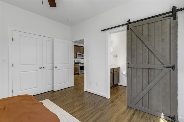 3401 Old Buncombe Rd, Greenville, SC 29617 - bedroom featuring a barn door, wood finished floors, baseboards, a closet, and ensuite bath