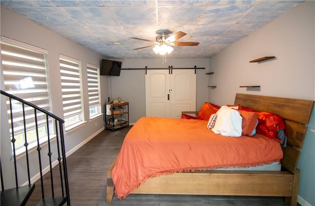 124 Grand Oak Cir, Pendleton, SC 29670 - bedroom with dark wood finished floors, a barn door, baseboards, and a ceiling fan