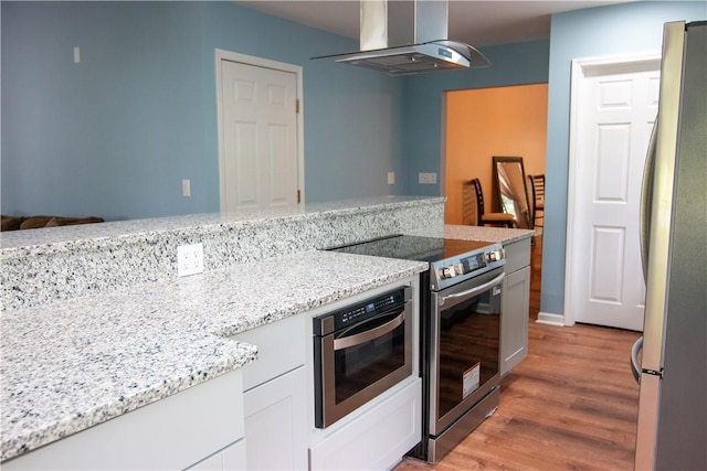 124 Grand Oak Cir, Pendleton, SC 29670 - kitchen with stainless steel appliances, range hood, light wood-type flooring, white cabinets, and light stone countertops