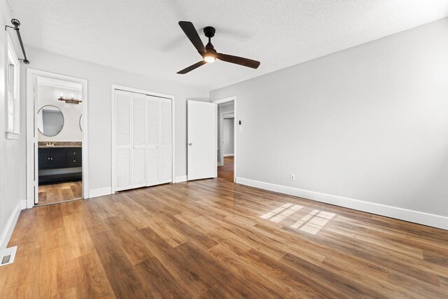 113 Woodhurst Dr, Hartwell, GA 30643 - unfurnished bedroom with wood finished floors, baseboards, a closet, connected bathroom, and ceiling fan