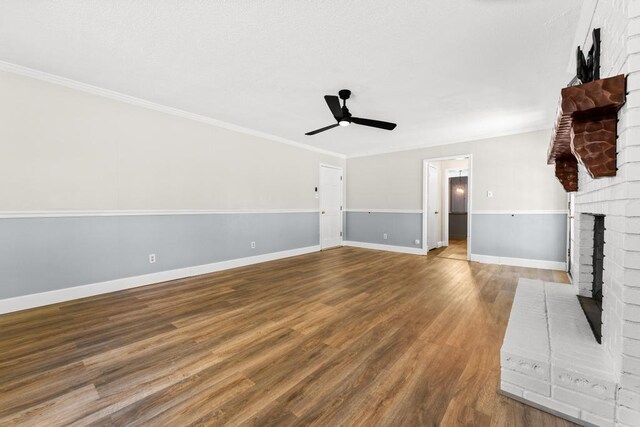 113 Woodhurst Dr, Hartwell, GA 30643 - unfurnished living room featuring a ceiling fan, a brick fireplace, wood finished floors, crown molding, and baseboards