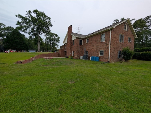 106 Emma Dr, Honea Path, SC 29654 - rear view of house featuring a chimney, brick siding, a lawn, and central AC