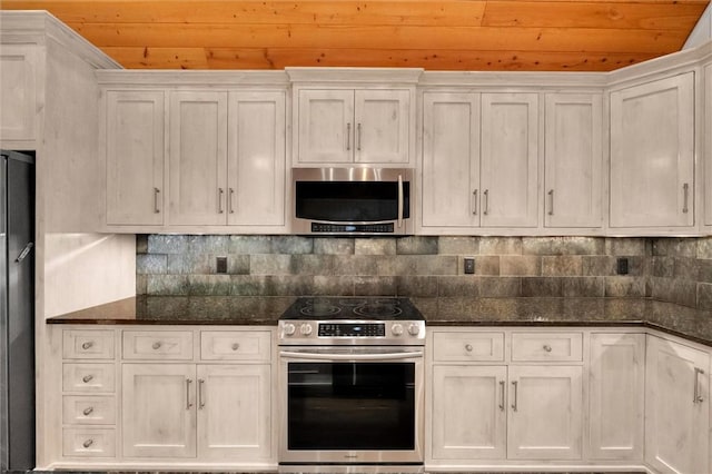 1457 Cheohee Valley Rd, Tamassee, SC 29686 - kitchen featuring appliances with stainless steel finishes, wooden ceiling, white cabinetry, dark stone countertops, and decorative backsplash