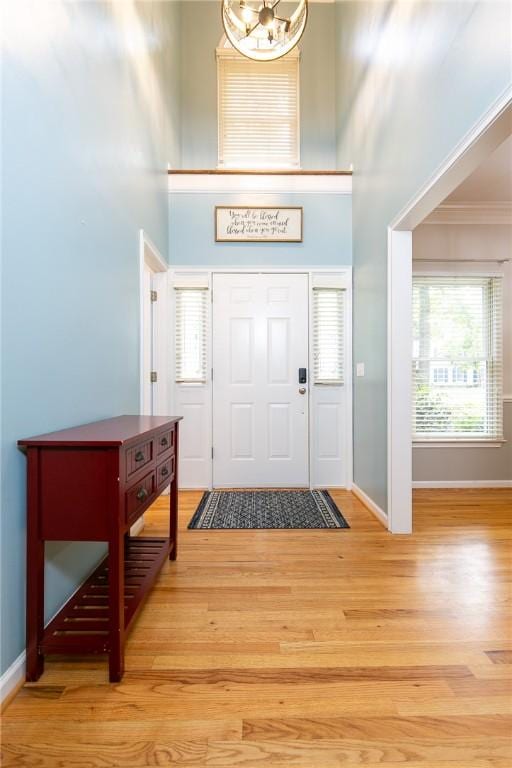 205 Shadow Oaks Dr, Easley, SC 29642 - foyer featuring wood finished floors, baseboards, a high ceiling, crown molding, and a chandelier