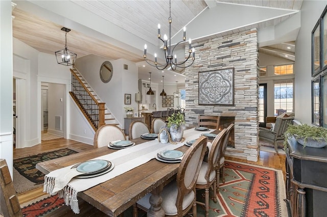 1819 Cross Creek Dr, Seneca, SC 29678 - dining area featuring high vaulted ceiling, a chandelier, wood finished floors, stairway, and a fireplace