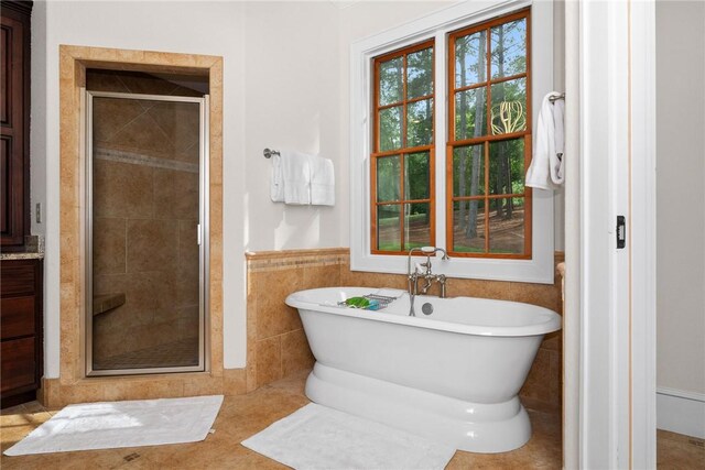 301 Augusta Way, Sunset, SC 29685 - bathroom featuring a shower stall, a freestanding tub, a wainscoted wall, and tile walls