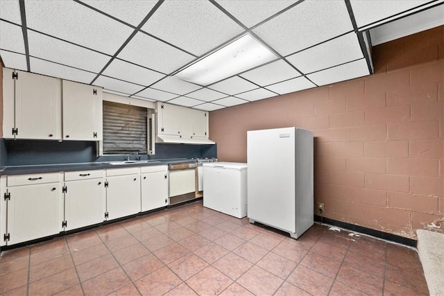 1122 Cox Rd, Anderson, SC 29621 - kitchen with concrete block wall, white appliances, a sink, a drop ceiling, and dark countertops
