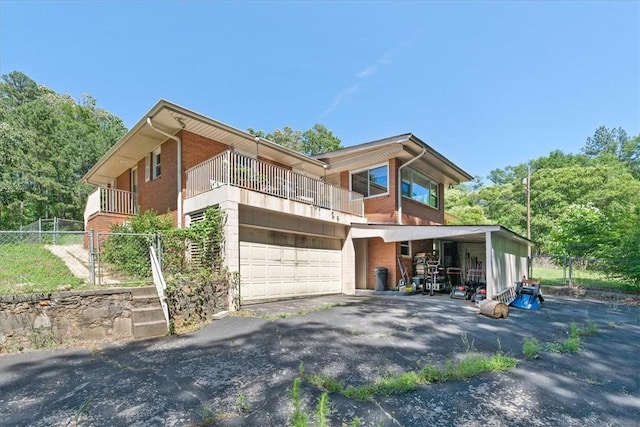 1122 Cox Rd, Anderson, SC 29621 - rear view of property featuring brick siding, driveway, a balcony, and an attached garage