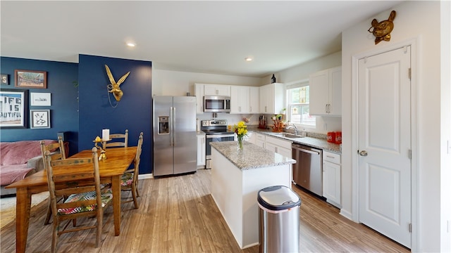 112 Queens Mill Ct, Pendleton, SC 29670 - kitchen featuring appliances with stainless steel finishes, a sink, light wood-type flooring, a center island, and light stone counters