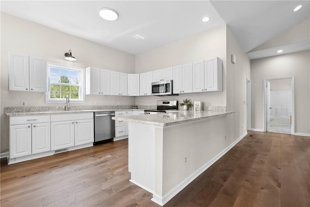 1316 E S 6th St, Seneca, SC 29678 - kitchen with stainless steel appliances, white cabinetry, wood finished floors, recessed lighting, and vaulted ceiling