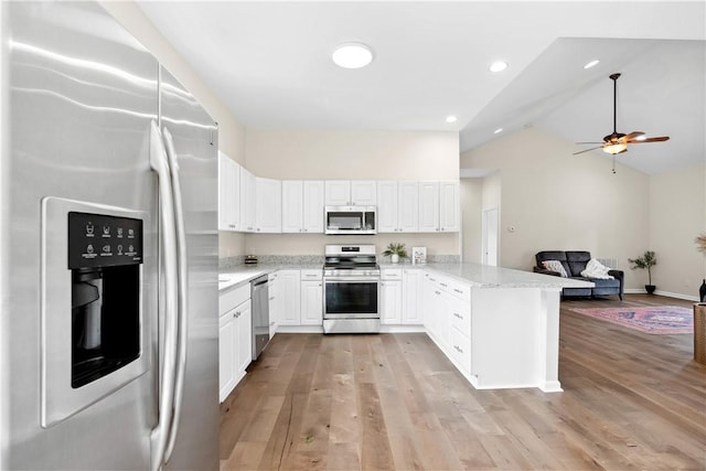 1316 E S 6th St, Seneca, SC 29678 - kitchen with stainless steel appliances, vaulted ceiling, open floor plan, a peninsula, and white cabinets
