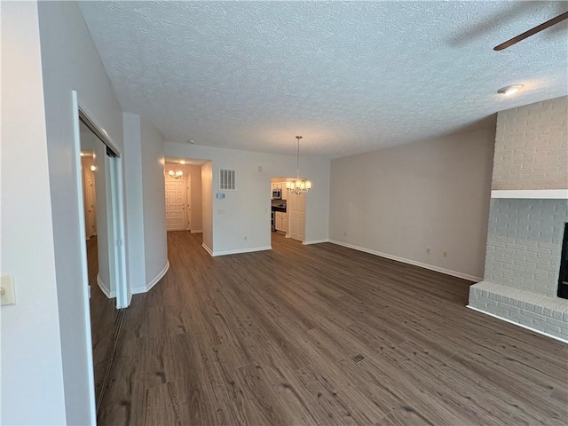 495 Tall Ship Dr Unit 340, Salem, SC 29676 - unfurnished living room featuring a chandelier, a textured ceiling, dark wood finished floors, a brick fireplace, and ceiling fan