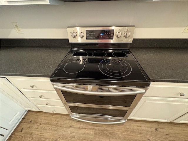 495 Tall Ship Dr Unit 340, Salem, SC 29676 - kitchen view of stainless steel electric range, white cabinetry, dark countertops, and wood finished floors
