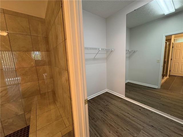 495 Tall Ship Dr Unit 340, Salem, SC 29676 - bathroom featuring a stall shower, a walk in closet, wood finished floors, baseboards, and a textured ceiling