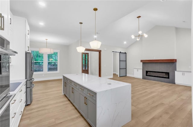 120 Thomason View Rd, Fountain Inn, SC 29644 - kitchen featuring gray cabinetry, a barn door, light wood-style flooring, a center island, and lofted ceiling