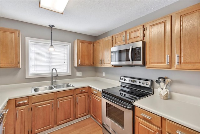 312 Northlake Dr, Anderson, SC 29625 - kitchen featuring appliances with stainless steel finishes, hanging light fixtures, light countertops, a textured ceiling, and light wood-type flooring