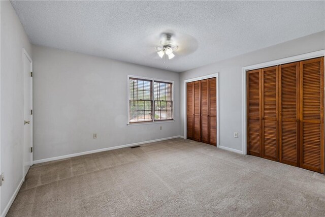 13036 W Camelia Ln, Seneca, SC 29678 - unfurnished bedroom featuring multiple closets, carpet flooring, a textured ceiling, baseboards, and ceiling fan