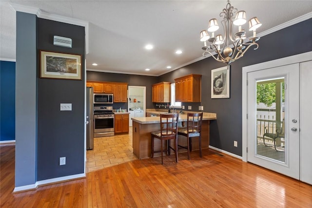 661 Playground Rd, Walhalla, SC 29691 - kitchen with stainless steel appliances, ornamental molding, a peninsula, light countertops, and brown cabinets