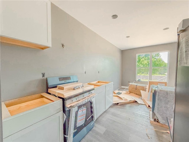 206 Highland Ave, Westminster, SC 29693 - kitchen featuring stainless steel range oven, light wood finished floors, white cabinets, and lofted ceiling