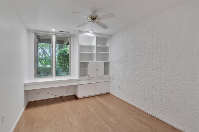 1613 S Arlington Dr, Seneca, SC 29672 - unfurnished room featuring brick wall, a ceiling fan, light wood-type flooring, a desk, and baseboards