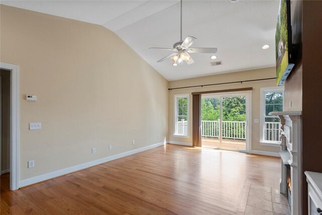 204 Lakeside Dr, Walhalla, SC 29691 - spare room with vaulted ceiling, a lit fireplace, a ceiling fan, light wood-type flooring, and baseboards